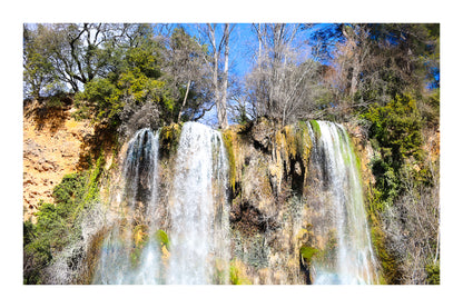 Deux pans de cascade à Sillans dévalant la falaise, entourés d’arbres nus et de mousse verte avec bordure