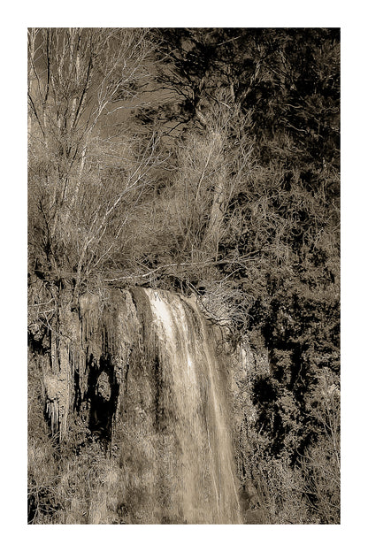 Gros plan vertical sur la cascade de Sillans avec eau ruisselante et mousses vertes accrochées à la falaise, vintage avec bordure