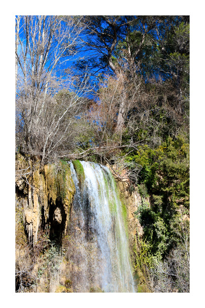 Gros plan vertical sur la cascade de Sillans avec eau ruisselante et mousses vertes accrochées à la falaise avec bordure