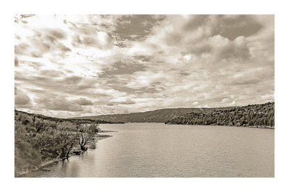 Large vue sur le lac de Sainte-Croix depuis un pont, rives boisées et grand ciel nuageux, vintage avec bordure