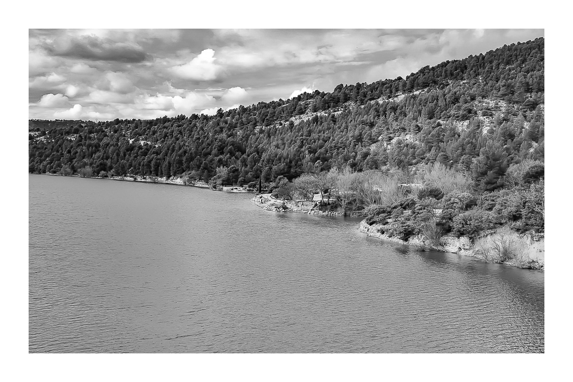 Rive du lac de Sainte-Croix aux eaux turquoise, bordée de pinèdes et de collines ocres, noir et blanc avec bordure