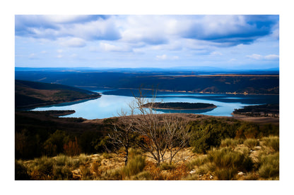 Vue panoramique sur le lac de Sainte-Croix, bras d’eau sinueux et collines provençales sous un ciel nuageux avec bordure