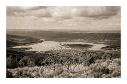 Vue panoramique sur le lac de Sainte-Croix, bras d’eau sinueux et collines provençales sous un ciel nuageux, vintage avec bordure