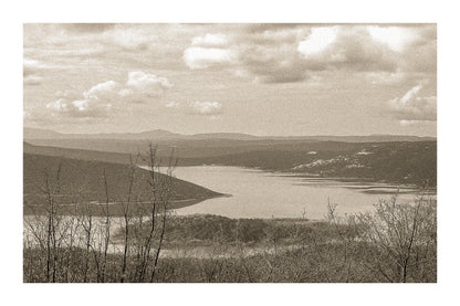 Long bras du lac de Sainte-Croix s’étirant entre collines et bosquets, sous un ciel nuageux, vintage avec bordure