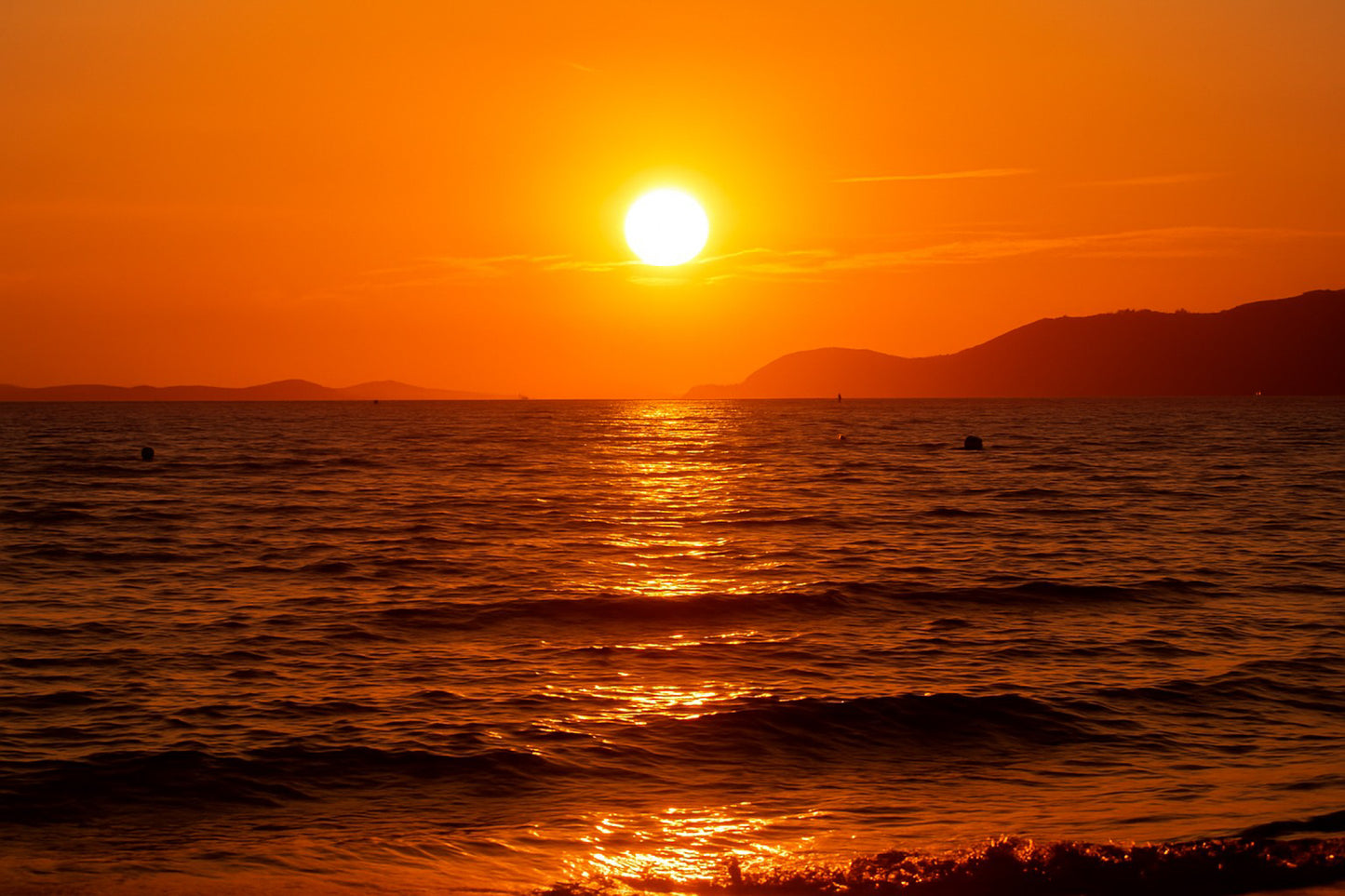 Coucher de soleil doré se reflétant sur la mer calme à la plage de l’Almanarre un soir d’été