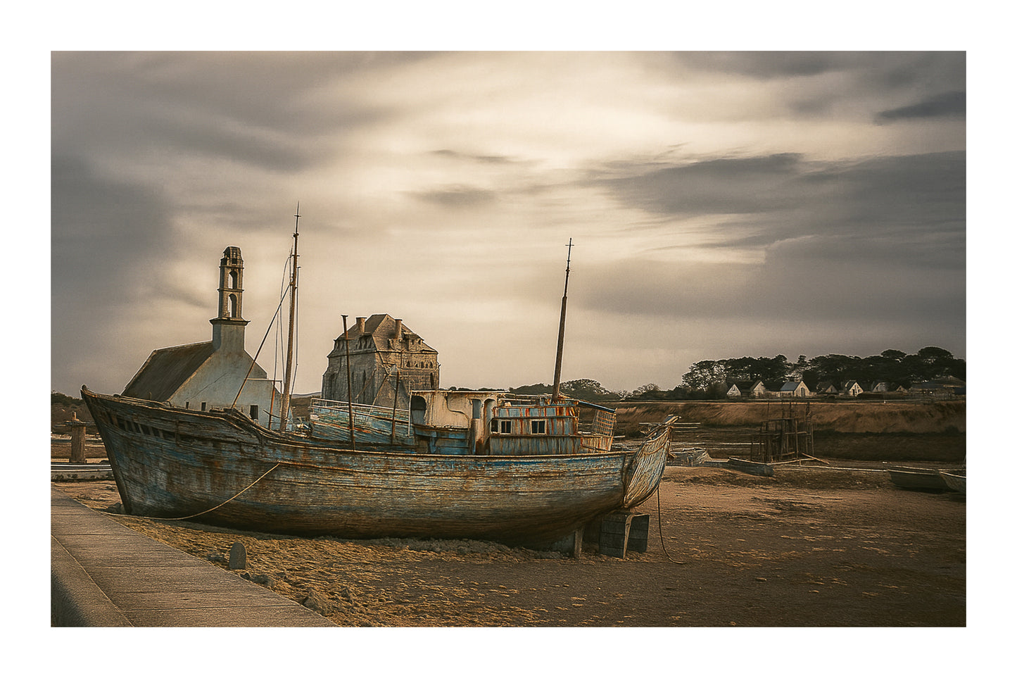 Épave bleue au premier plan devant chapelle et maisons, ciel doré au-dessus du port de Camaret, avec bordure