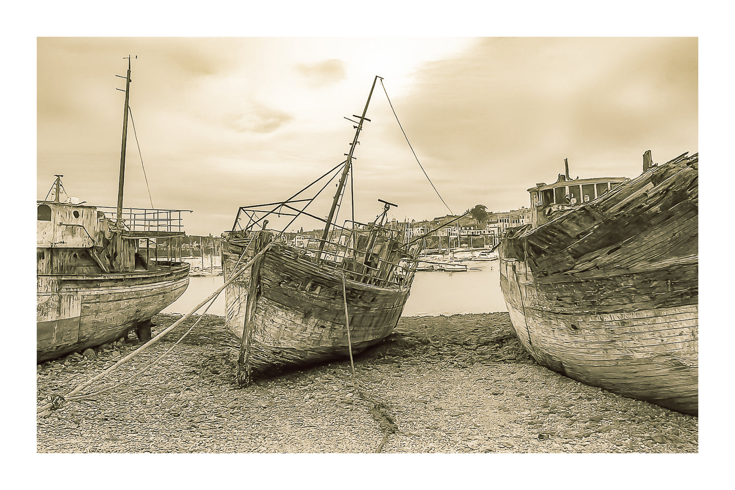 Vieille coque bleue au centre des épaves sur galets, ville de Camaret au fond, vintage avec bordure