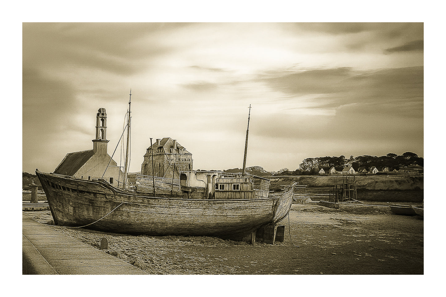 Épave bleue au premier plan devant chapelle et maisons, ciel doré au-dessus du port de Camaret, vintage avec bordure