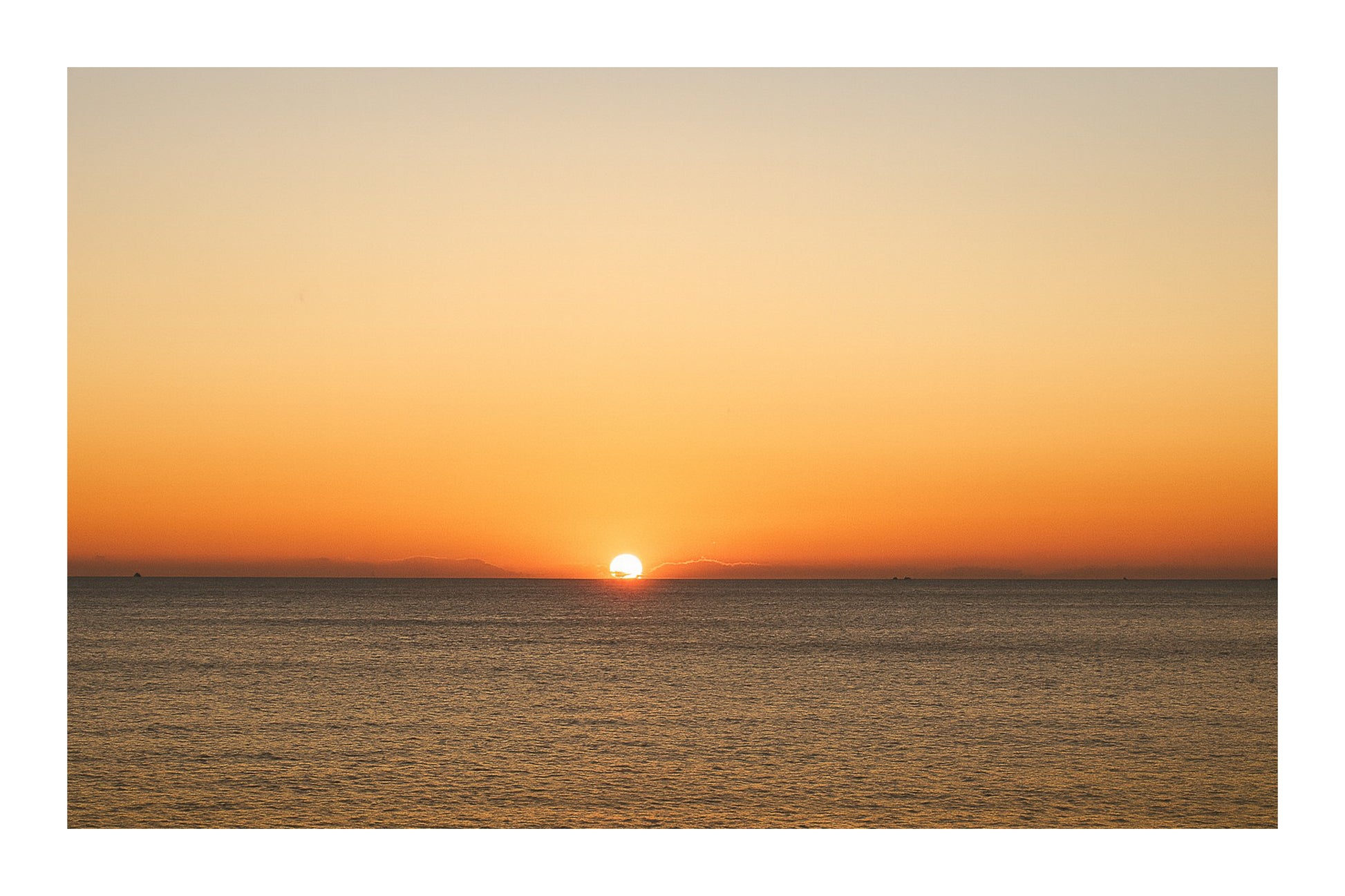 gros plan de l’astre couchant à l’horizon marin, ciel orange à Carry-le-Rouet, avec bordure