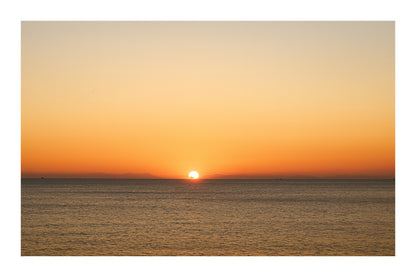 gros plan de l’astre couchant à l’horizon marin, ciel orange à Carry-le-Rouet, avec bordure