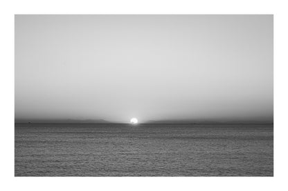 gros plan de l’astre couchant à l’horizon marin, ciel orange à Carry-le-Rouet, noir et blanc avec bordure