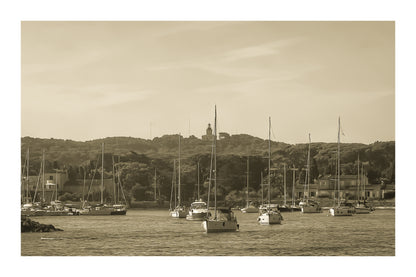 Voiliers au mouillage devant le village de Porquerolles avec le phare sur la colline, ciel bleu et pinède méditerranéenne, vintage vec bordure
