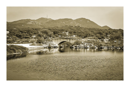 Petit pont en arc sur le canal intérieur des Embiez avec collines en arrière-plan, rendu sépia avec bordure
