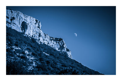 Falaise de la Sainte-Baume et lune baignant dans une dominante bleutée, atmosphère nocturne et mystérieuse avec bordure