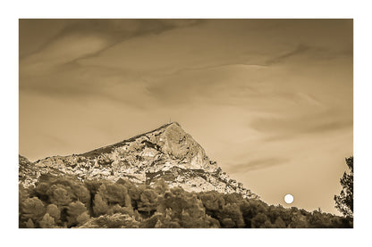 Lune jaune se levant près de la montagne Sainte-Victoire, ciel bleu aux nuages roses, pins en premier plan au crépuscule, vintage avec bordure