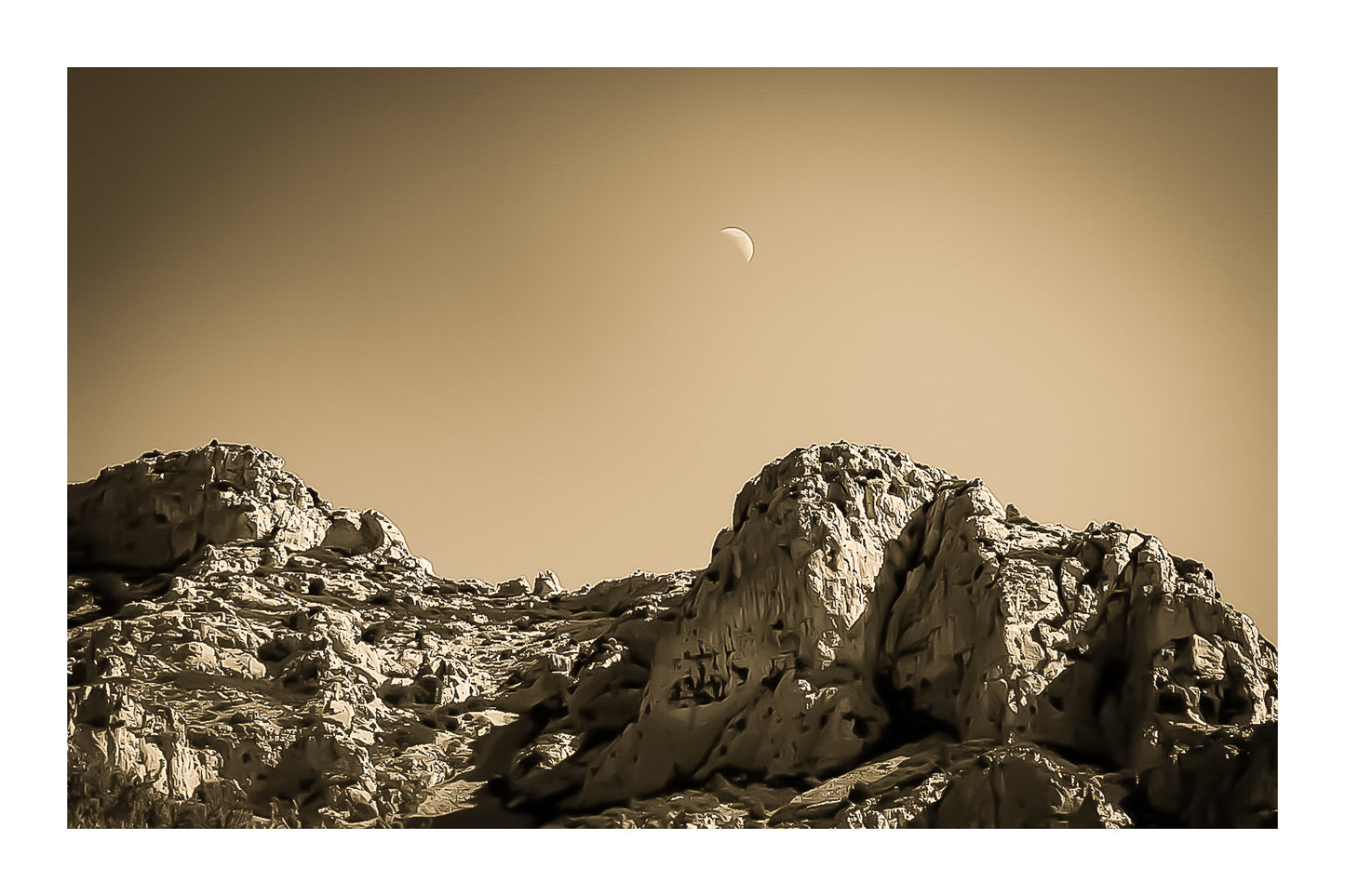 Demi-lune au-dessus des crêtes calcaires de Sugiton, ciel bleu profond et relief minéral, vintage avec bordure