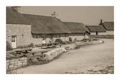 Longère de Meneham avec tables en bois, mur de pierre et toit de chaume, traitement vintage sépia - Kerlouan, Finistère, avec bordure