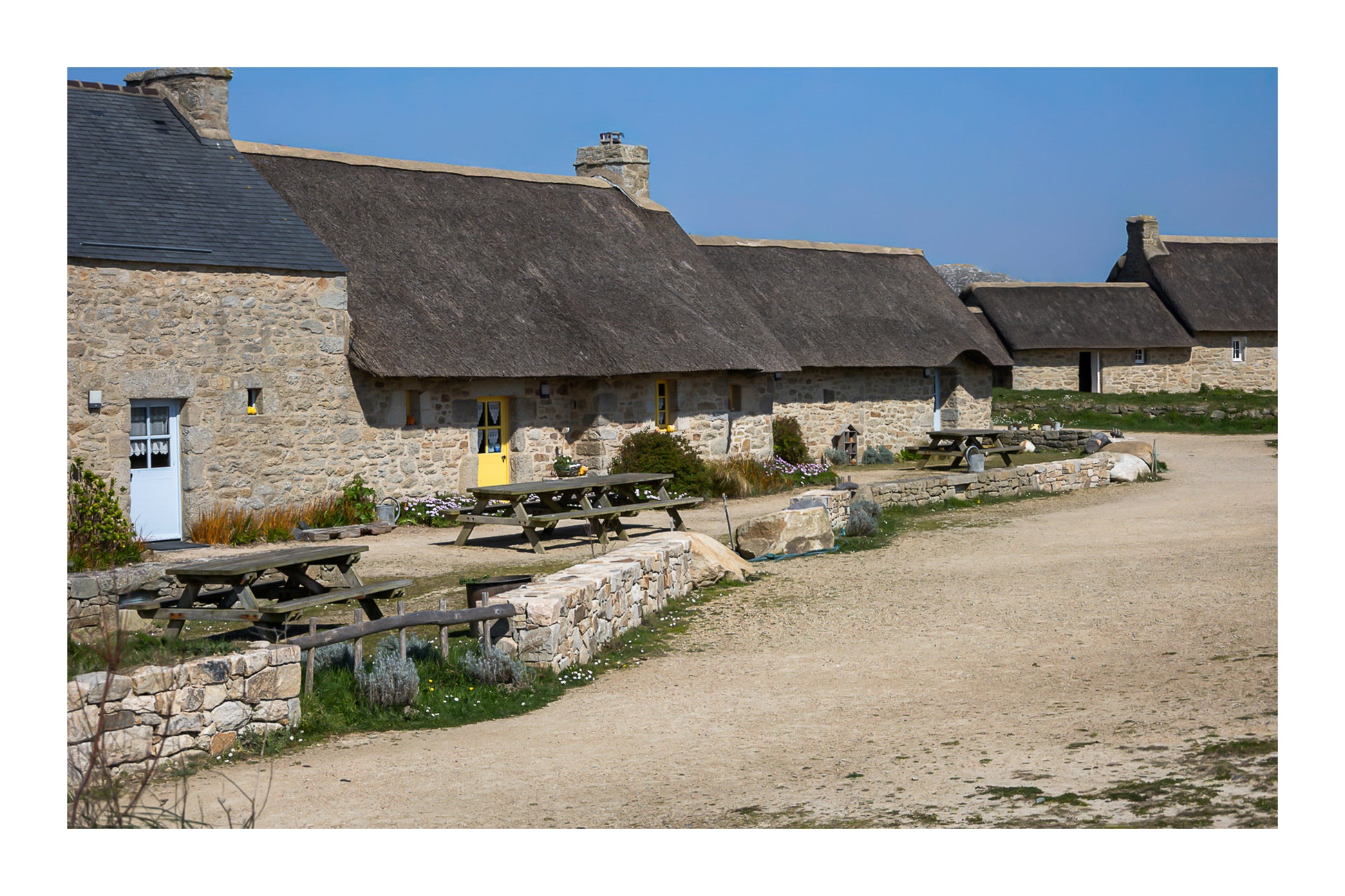 Longère de Meneham avec tables en bois, mur de pierre et toit de chaume, coueur avec bordure - Kerlouan, Finistère, avec bordure
