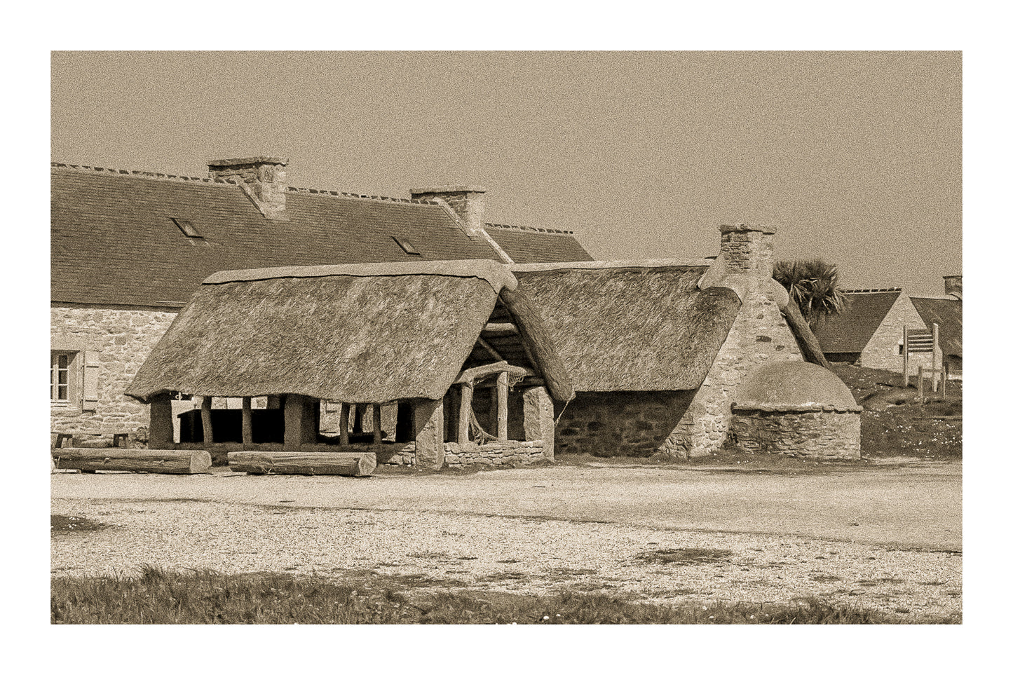Ancien abri couvert de chaume et four traditionnel en pierre à Meneham, rendu vintage sépia avec bordure - Côte des Légendes, Bretagne