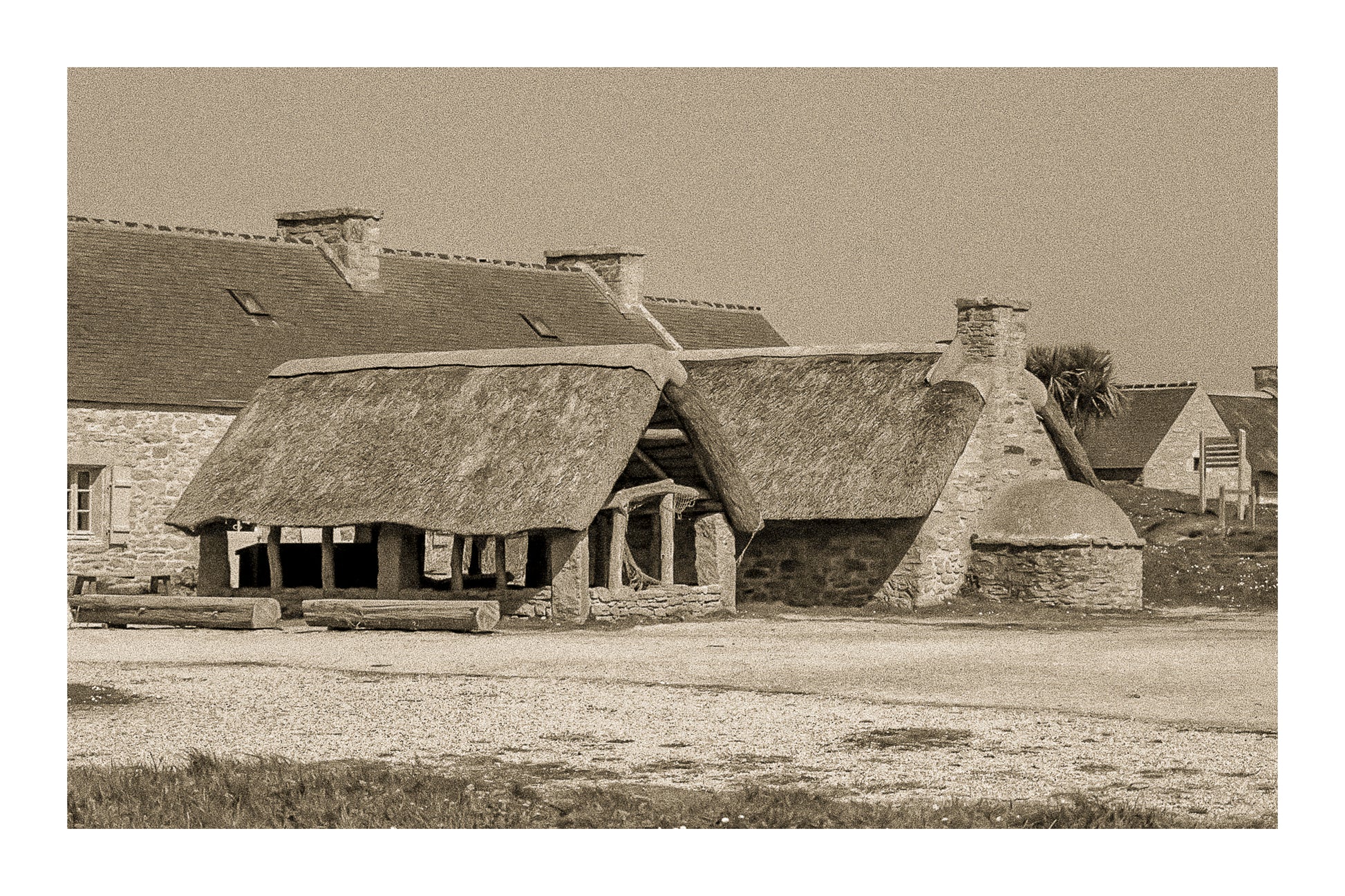 Ancien abri couvert de chaume et four traditionnel en pierre à Meneham, rendu vintage sépia avec bordure - Côte des Légendes, Bretagne