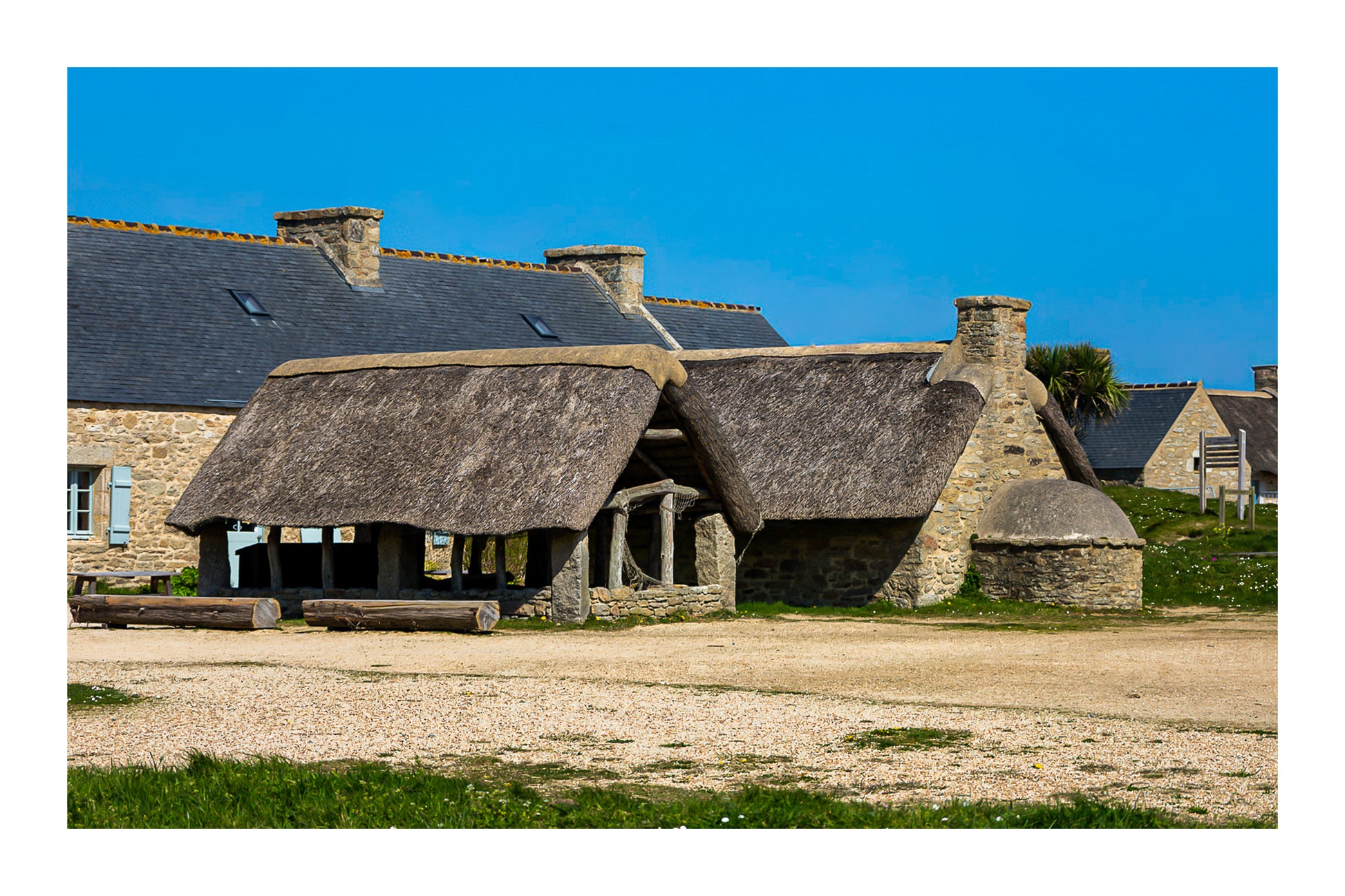 Ancien abri couvert de chaume et four traditionnel en pierre à Meneham, couleur avec bordure - Côte des Légendes, Bretagne