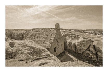 La maison emblématique de Meneham nichée entre deux énormes blocs de granit, vue d’ensemble en sépia vintage avec bordure