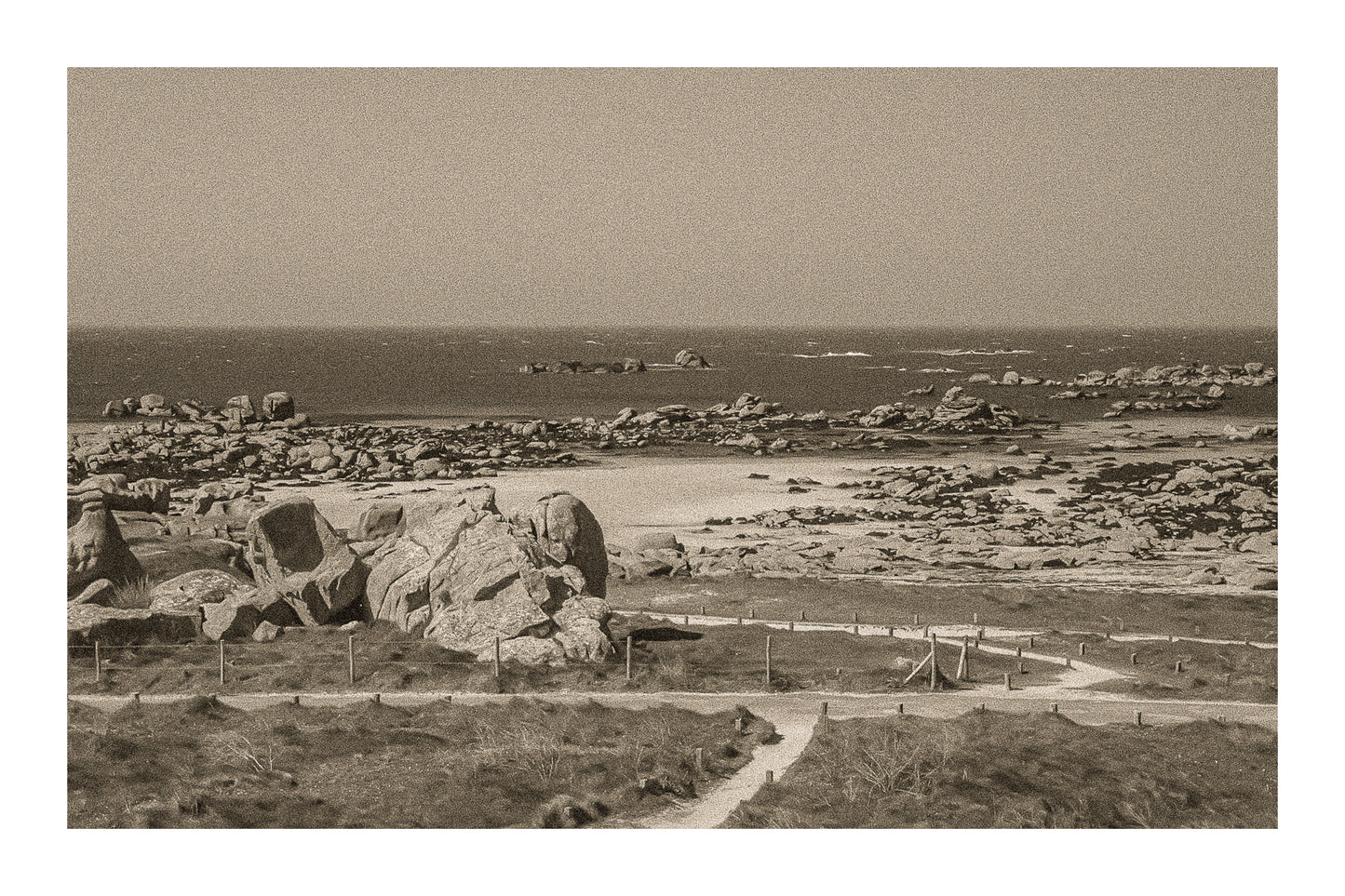 Chemins de sable entre landes et chaos granitiques au bord de mer, Meneham, rendu vintage sépia avec bordure