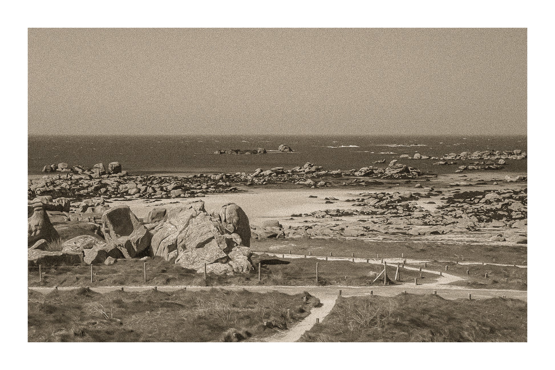 Chemins de sable entre landes et chaos granitiques au bord de mer, Meneham, rendu vintage sépia avec bordure