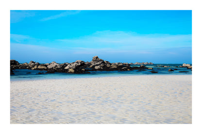 Grande plage claire avec rochers épars et ligne d’horizon marine, couleur avec bordure à Meneham