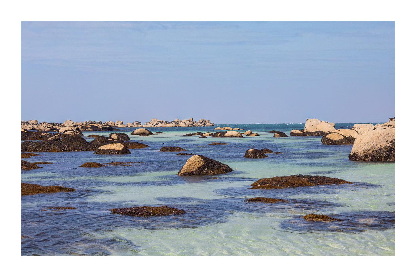 Rochers et laisses de mer à marée basse sur sable clair, couleur avec bordure, site de Meneham en Bretagne