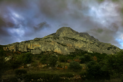 Montagne Sainte-Victoire sous un ciel d’orage vert et violet, vue depuis le pied de la falaise