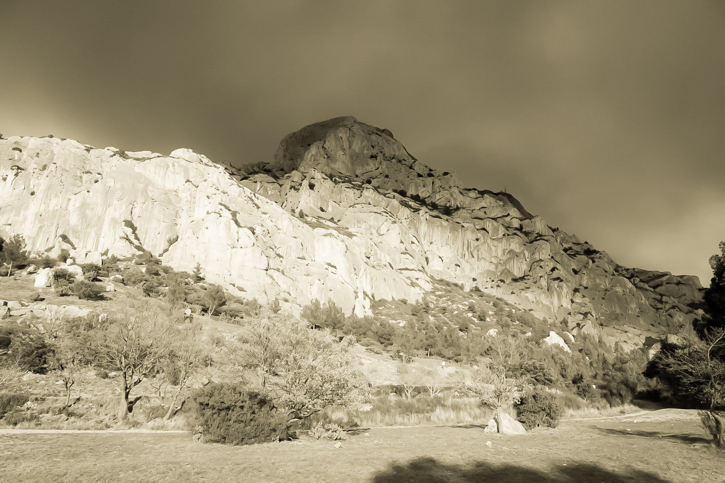 Falaise de la Sainte-Victoire dorée par le soleil avec gros nuages noirs au-dessus, vintage