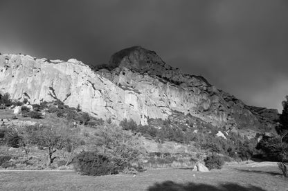 Falaise de la Sainte-Victoire dorée par le soleil avec gros nuages noirs au-dessus, noir et blanc