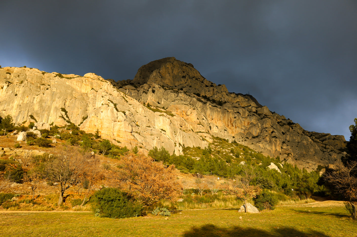Falaise de la Sainte-Victoire dorée par le soleil avec gros nuages noirs au-dessus