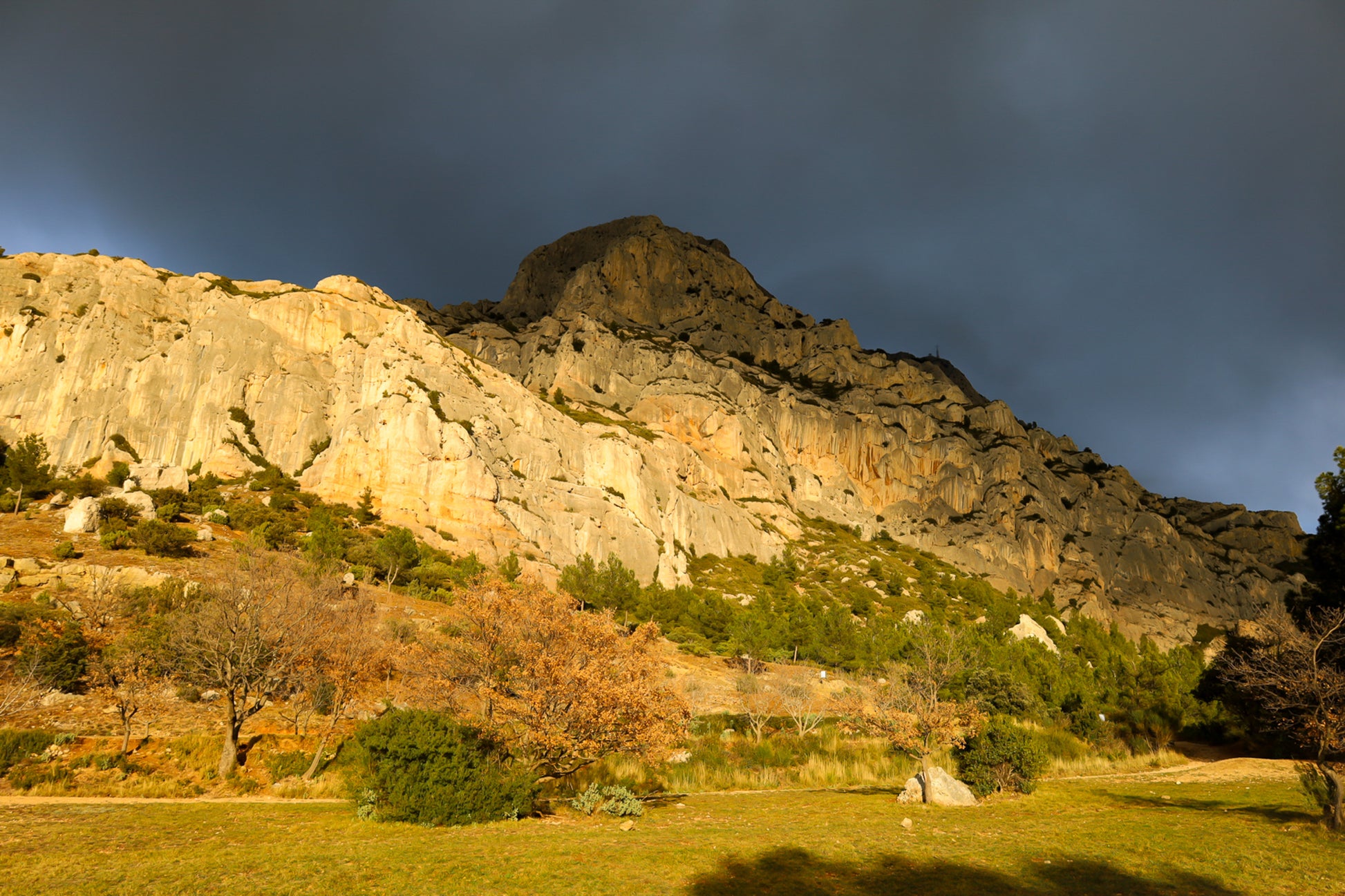 Falaise de la Sainte-Victoire dorée par le soleil avec gros nuages noirs au-dessus