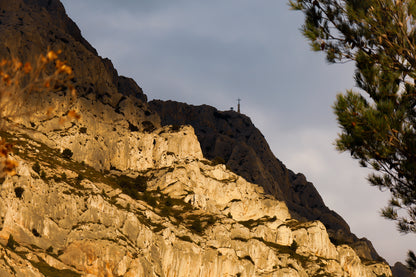 Croix au sommet de la Sainte-Victoire se détachant sur un ciel sombre