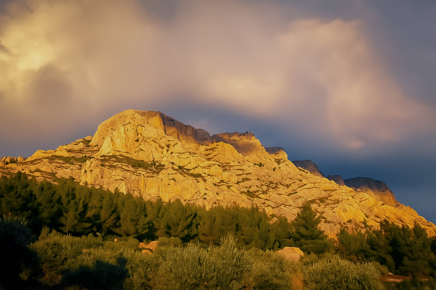 Crête de la Sainte-Victoire baignée de lumière dorée sous un ciel de nuages violets