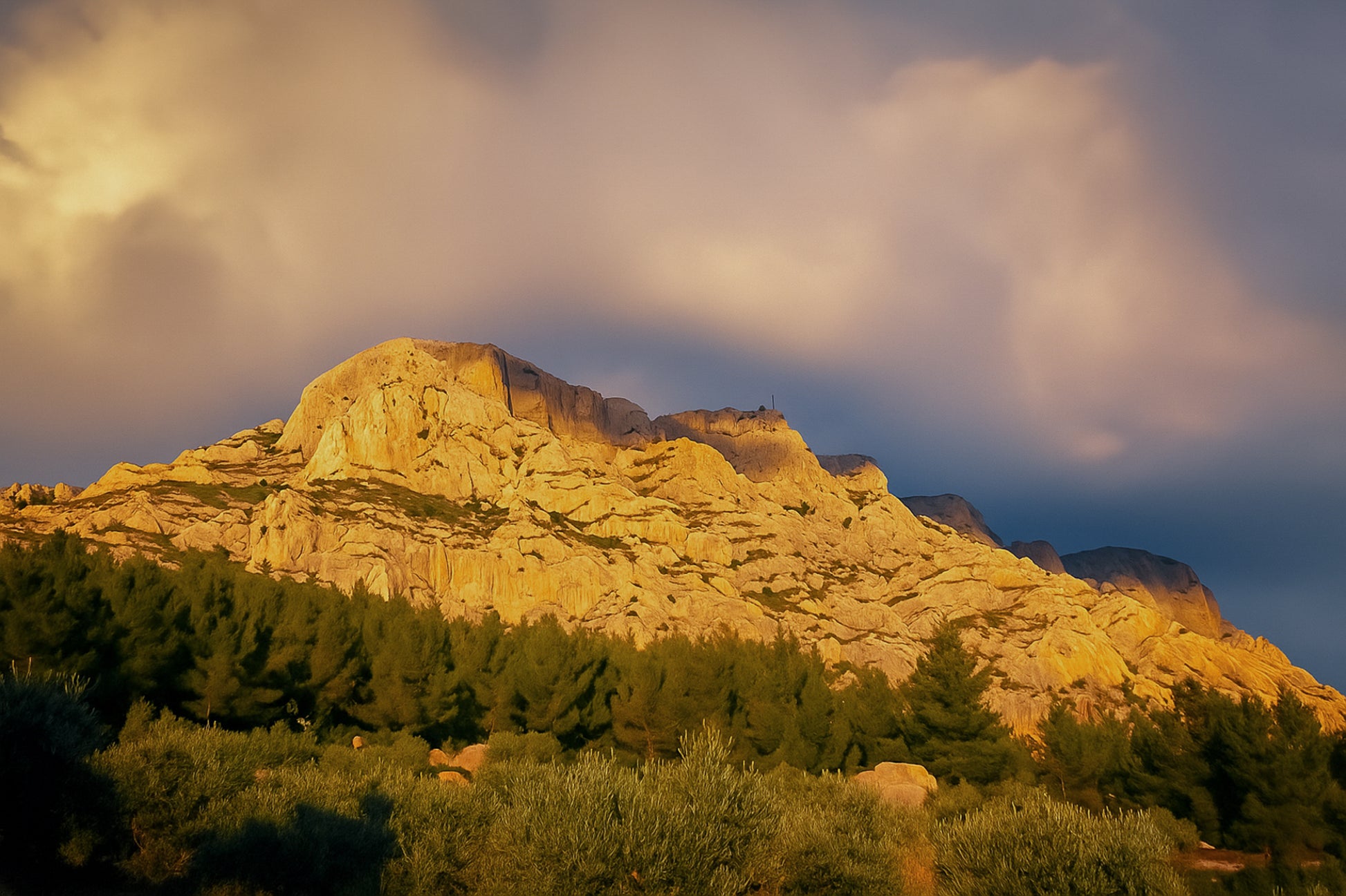 Crête de la Sainte-Victoire baignée de lumière dorée sous un ciel de nuages violets