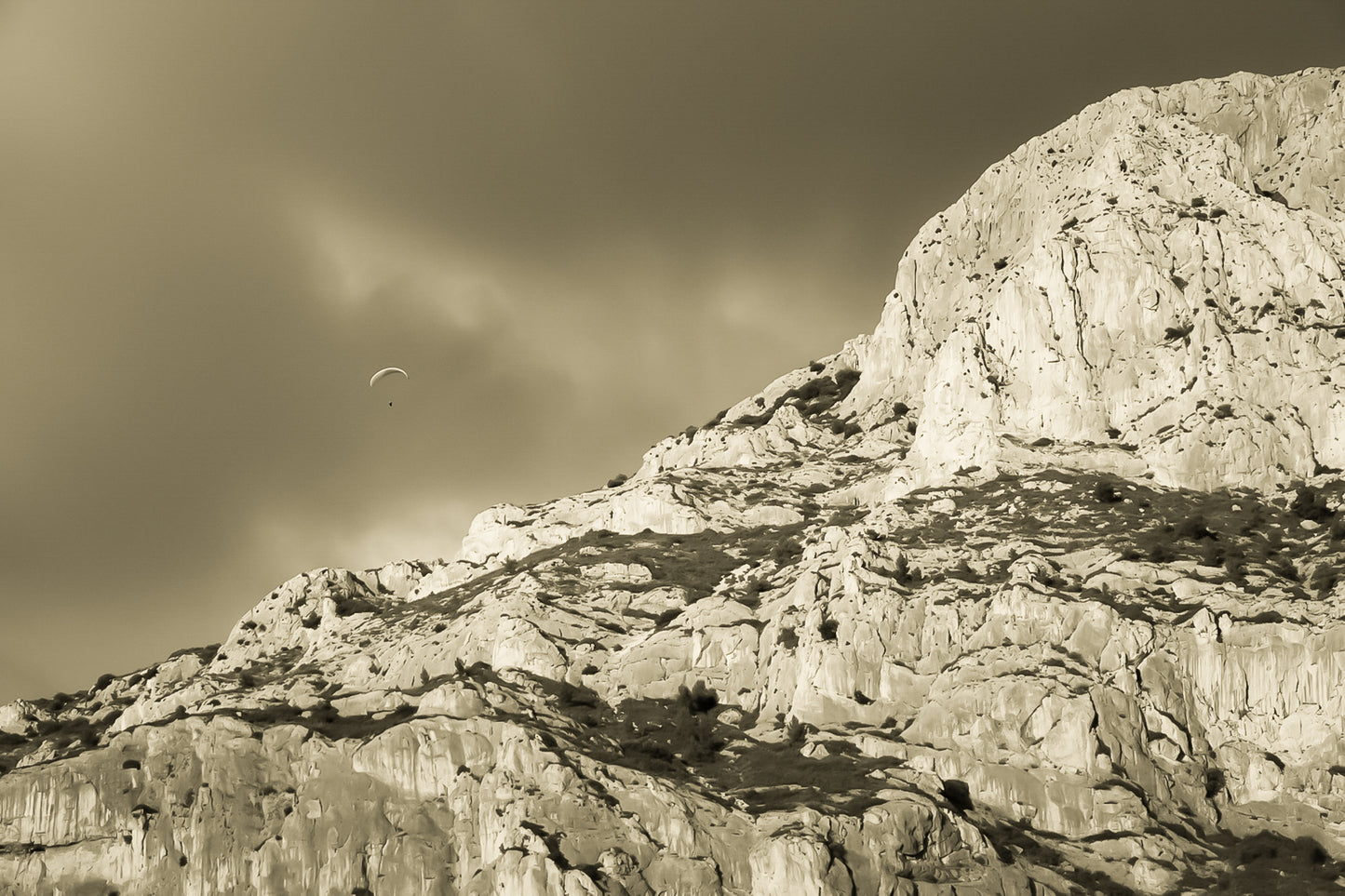 Parapente dans le ciel sombre au-dessus des falaises claires de la Sainte-Victoire, vintage