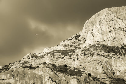 Parapente dans le ciel sombre au-dessus des falaises claires de la Sainte-Victoire, vintage
