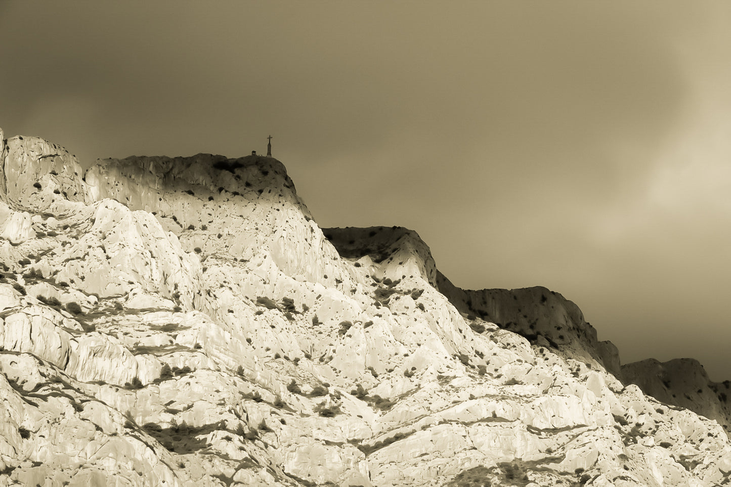 Croix de la Sainte-Victoire éclairée par le soleil sur fond de nuages sombres, vintage