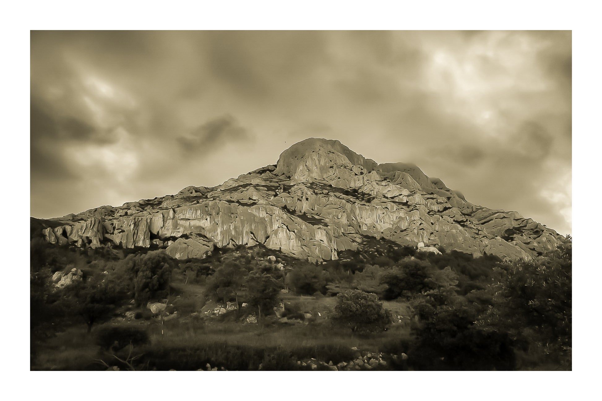 Montagne Sainte-Victoire sous un ciel d’orage vert et violet, vue depuis le pied de la falaise, vintage avec bordure