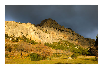 Falaise de la Sainte-Victoire dorée par le soleil avec gros nuages noirs au-dessus avec bordure