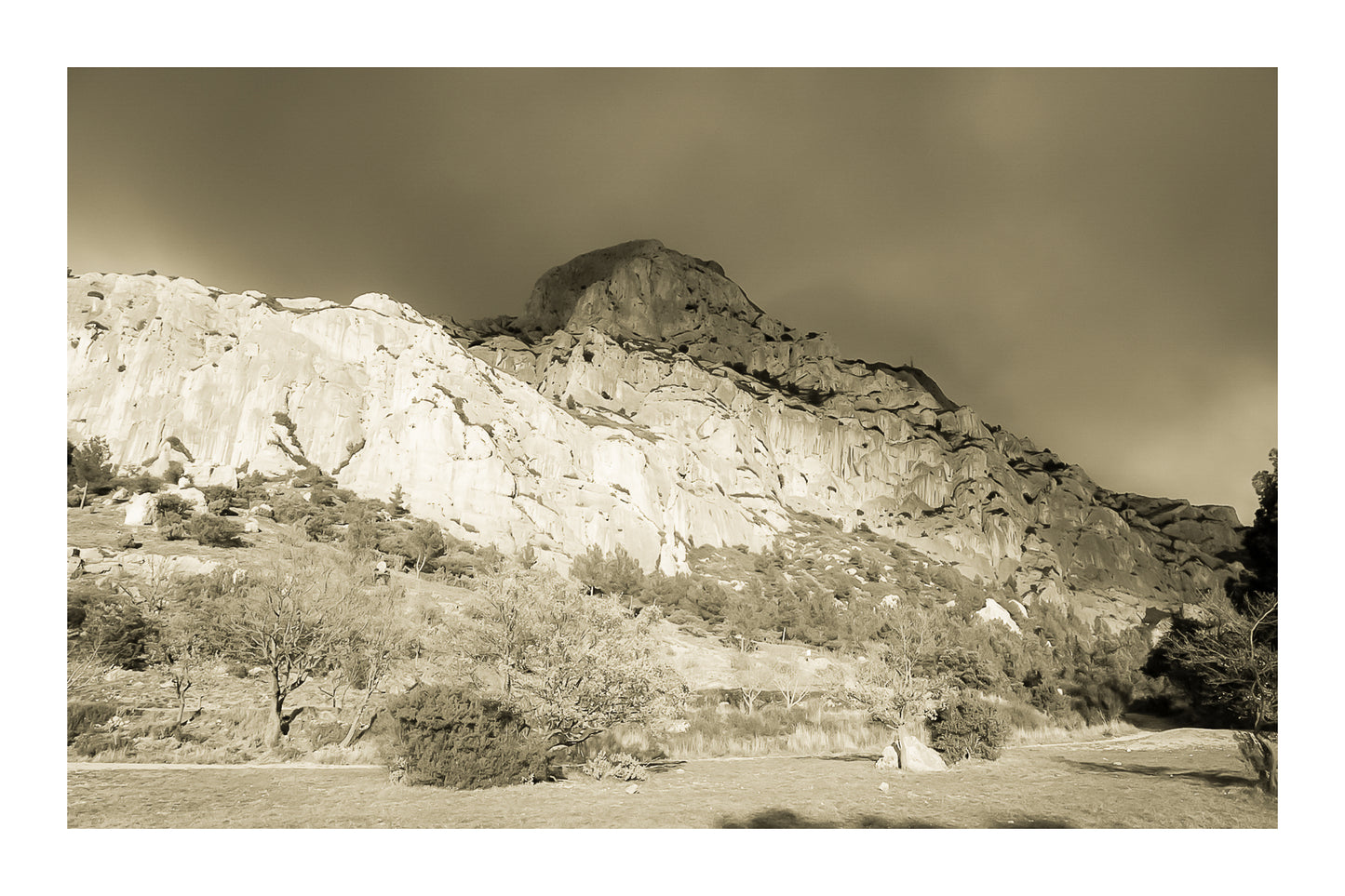 Falaise de la Sainte-Victoire dorée par le soleil avec gros nuages noirs au-dessus, vintage avec bordure