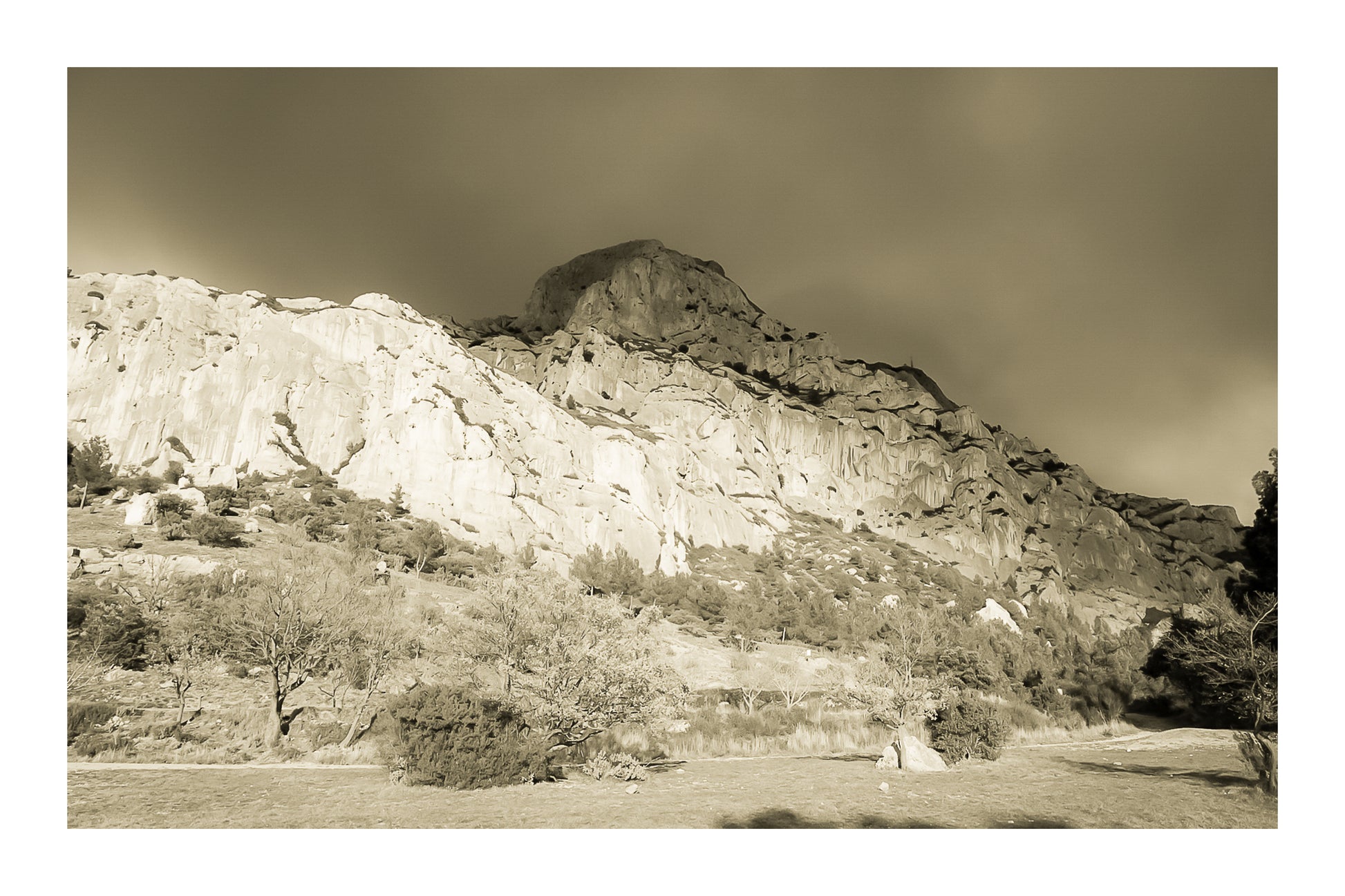 Falaise de la Sainte-Victoire dorée par le soleil avec gros nuages noirs au-dessus, vintage avec bordure