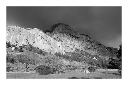 Falaise de la Sainte-Victoire dorée par le soleil avec gros nuages noirs au-dessus, noir et blanc avec bordure