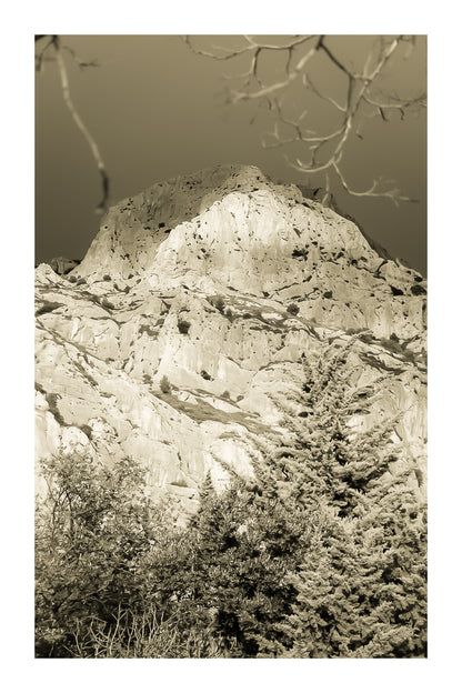 Sommet de la Sainte-Victoire encadré de branches, éclairé sur fond de ciel noir, vintage avec bordure