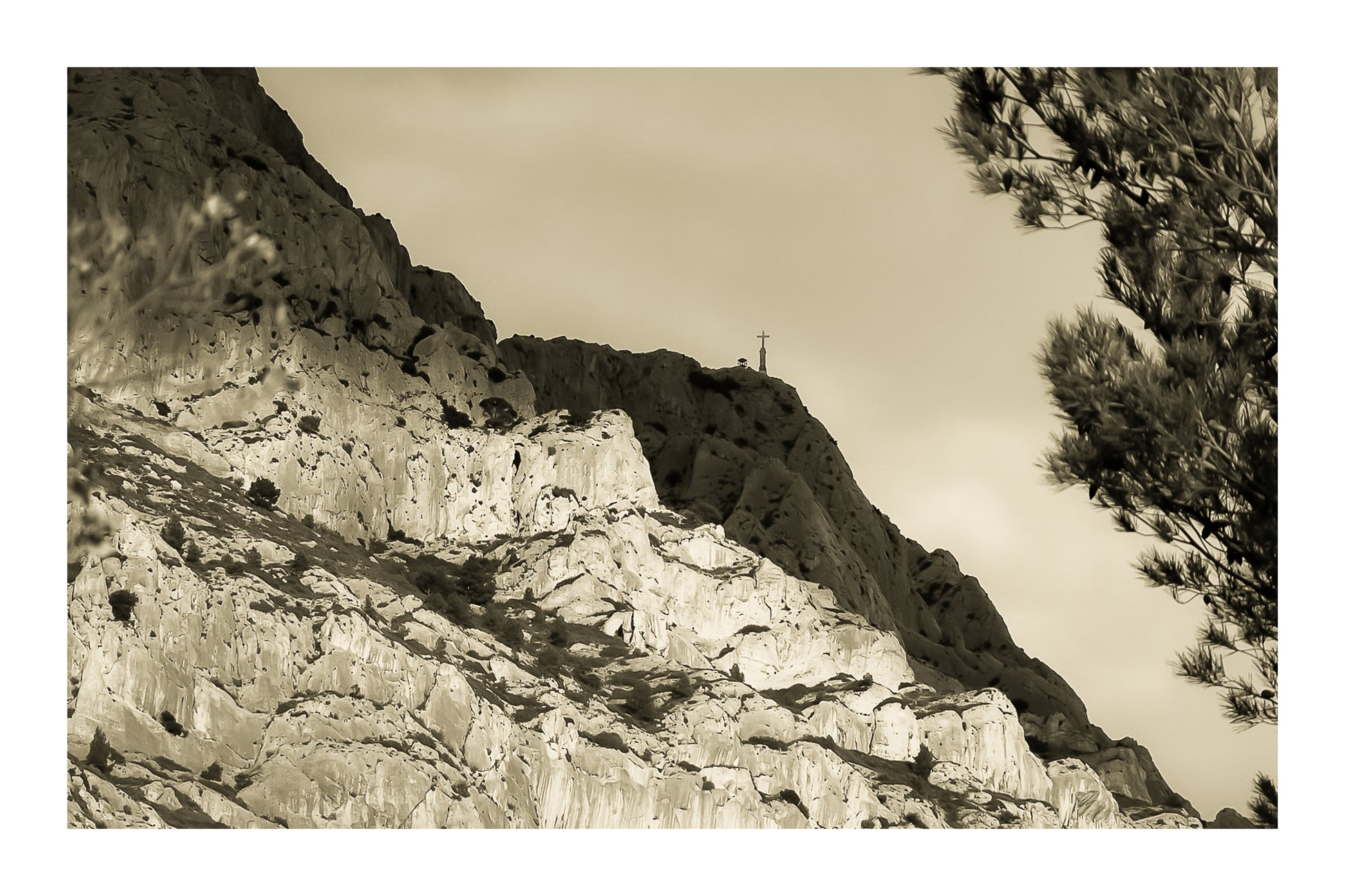 Croix au sommet de la Sainte-Victoire se détachant sur un ciel sombre, vintage avec bordure