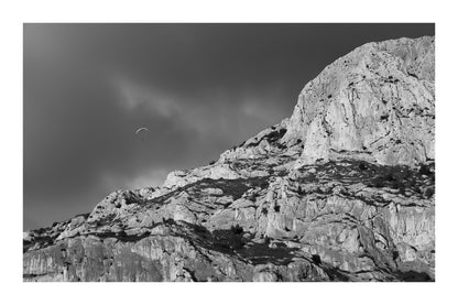 Parapente dans le ciel sombre au-dessus des falaises claires de la Sainte-Victoire, vintage avec bordure