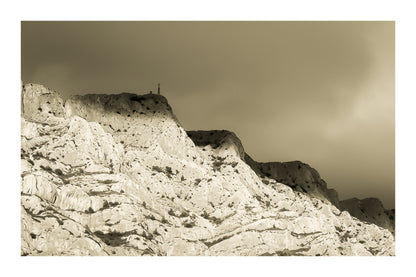 Croix de la Sainte-Victoire éclairée par le soleil sur fond de nuages sombres, vintage avec bordure